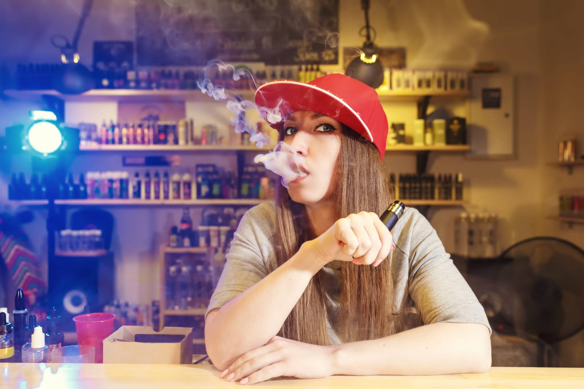 Smoke shop física de profuctos para vapear y fumar donde una mujer joven vapea.